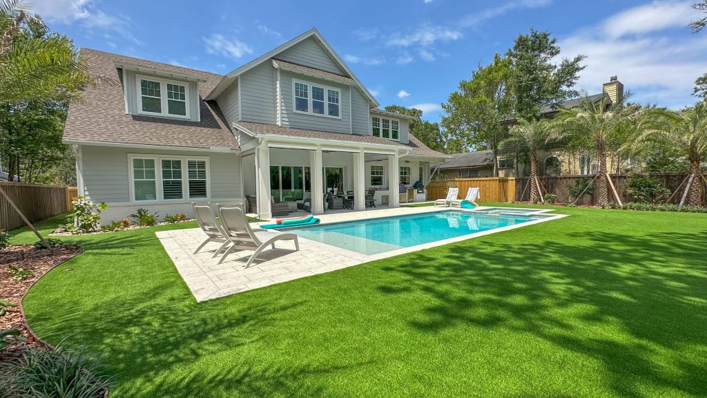 Landscape trimming and neat lawn care around a modern home with a pool in Atlantic Beach, FL