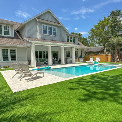 Landscape trimming and neat lawn care around a modern home with a pool in Atlantic Beach, FL